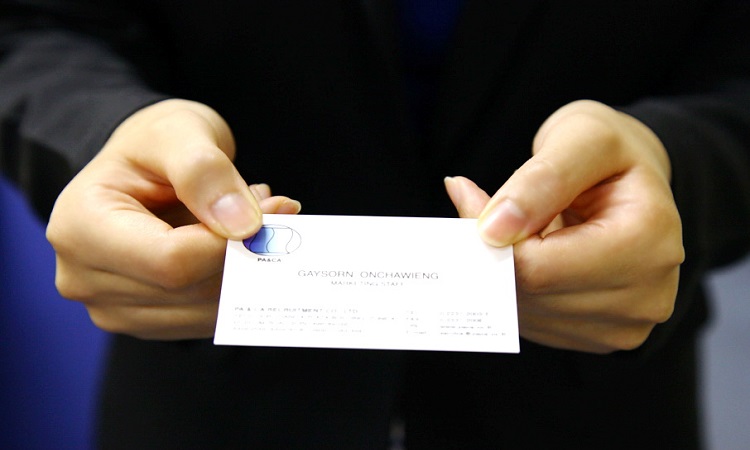 Two hands holding business card